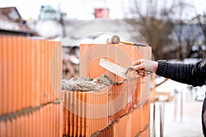 Construction bricklayer worker building walls with fresh bricks and tools