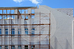 Construction of a building with external insulation and plaster using scaffolding