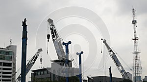 Construction building site with heavy euipment crane while working in sunset time in bangkok