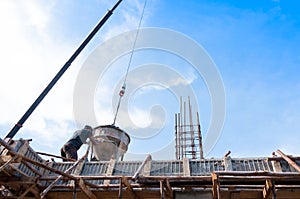 Construction building workers at construction site pouring concrete in form