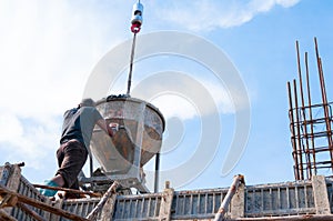 Construction building workers at construction site pouring concrete in form