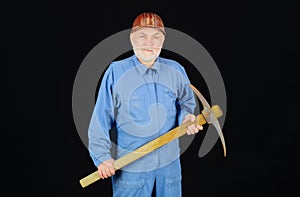 Construction and building works. Bearded man in coveralls and hard hat with pick-axe. Craftsman or contractor with