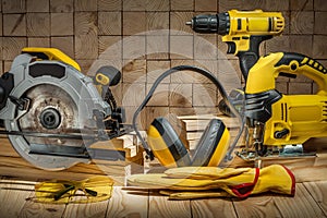 Construction carpentry tools electric corded circular saw jigsaw cordless drill earphones gloves goggles on wooden background