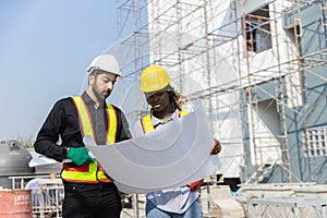 Construction civil engineer man and woman African American checking quality of work in construction site. Team of various