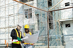Construction civil engineer man and woman African American checking quality of work in construction site. Team of various