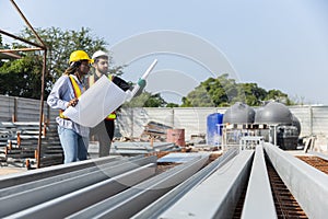 Construction civil engineer man and woman African American checking quality of work in construction site. Team of various