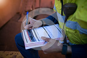 Construction coal miner supervisor conducting safety checking on job hazards analysis on hot work permit before sign off