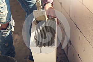 Construction concept, Bricklayer worker installing wite blocks to build wall at construction