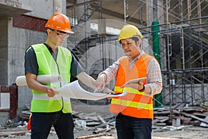 Construction concept of Engineer and Architect working with construction model and blueprint at construction site, Engineer and