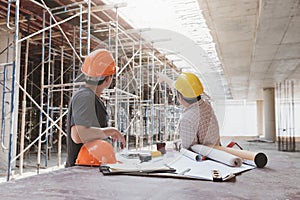 Construction concept of Engineer and Architect working with construction model and blueprint at construction site, Engineer and