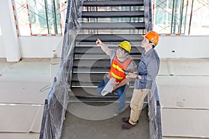 Construction concept of Engineer and Architect working with construction model and blueprint at construction site, Engineer and