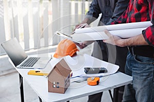 Construction concept of Engineer and Architect working at Construction Site with blue print, Engineer and Architect discussing