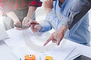 Construction concept of Engineer and Architect working at Construction Site with blue print, Engineer and Architect discussing