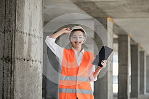 Construction concept of Engineer or Architect working at Construction Site. A woman with a tablet at a construction site. Bureau