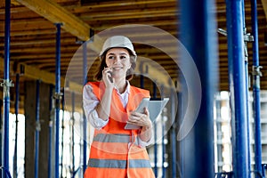 Construction concept of Engineer or Architect working at Construction Site. A woman with a tablet at a construction site. Bureau