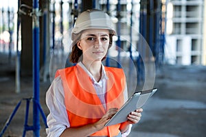 Construction concept of Engineer or Architect working at Construction Site. A woman with a tablet at a construction site. Bureau