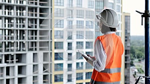 Construction concept of Engineer or Architect working at Construction Site. A woman with a tablet at a construction site. Bureau
