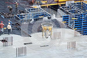 Construction of concrete foundation of new building. Aerial view of construction site workers leveling cement in