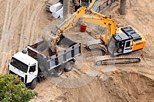 Construction of concrete foundation of new building. Construction machinery, excavator, top view