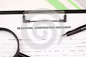 Construction contract form on A4 tablet lies on office table with pen and magnifying glass