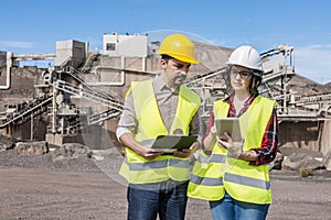 Construction coworkers using tablet on industrial area photo