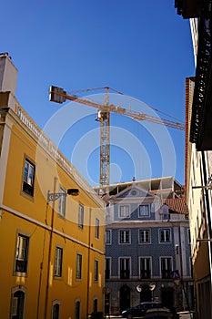 Construction crane above the colorful buildings in Lisbon, Portugal