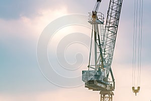 Construction crane against blue and pink sky. Real estate industry. Construction crane use reel lift up equipment in construction