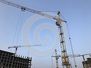 Construction crane on a background of blue sky. crane for moving heavy concrete blocks. construction of a parking lot. a new area