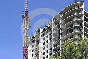 the construction crane and the building against the blue sky