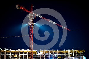 Construction crane, building site lighting at night, construction of an apartment building, the construction site