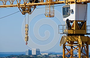 Construction crane cabin hook pulley sideview with city aerial b