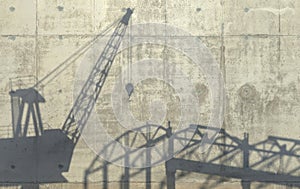 Construction crane and carcass of an unfinished building cast a shadow on the concrete wall. Conceptual creative illustration with