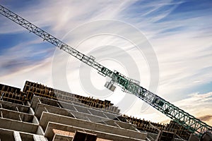 Construction crane on the construction of a monolithic house on a background of beautiful sky