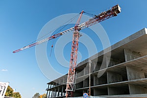 Construction crane at a construction site in the city against the blue sky. Construction of a new building.