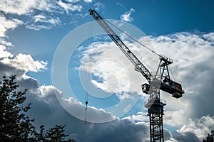 Construction crane elevating materials on building site