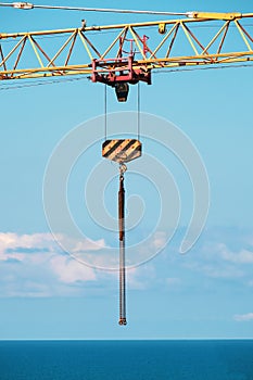Construction crane and hook with chain  on blue sky background