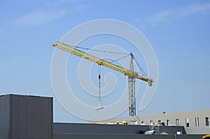 Construction crane lifting heavy objects ar worksite