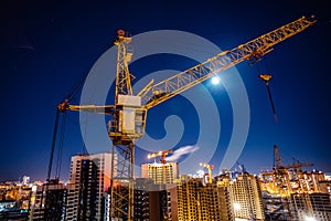 Construction crane at modern buildings construction site, night view