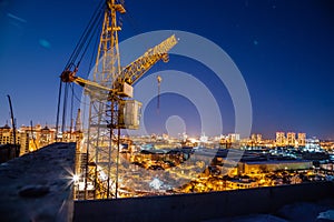 Construction crane at modern buildings construction site, night view