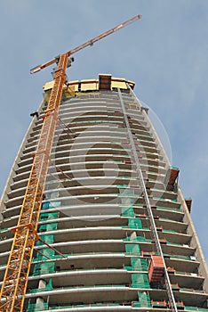 Construction crane and multi-storey house. Limassol, Cyprus