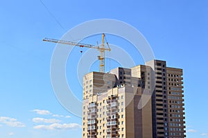 Construction crane near the newly built block of flats