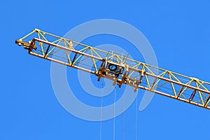 Construction crane operating and lifting cargo, blue sky background photo