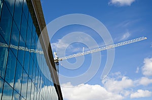 Construction Crane Over a Glass Building with Blue Sky