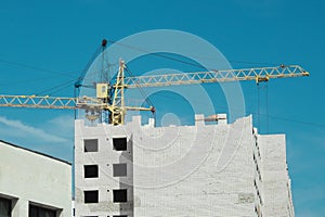 Construction crane over an unfinished building. Building construction