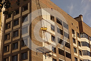 Construction crane raising a platform on a construction site