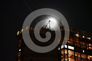 Construction Crane silhouetted by a full moon