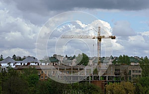 Construction crane on site with cloudy sky