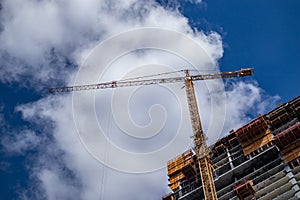 Construction crane on a skyscraper building, blue sky background, spring day