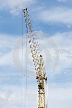 Construction crane tower against a blue sky.