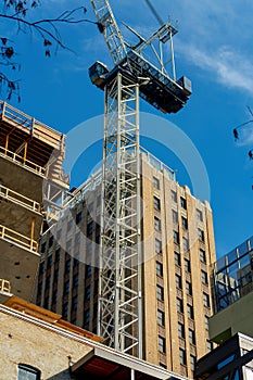 Construction crane with towering buildings in late afternoon sun in parking garage in downtown city san antonio texas